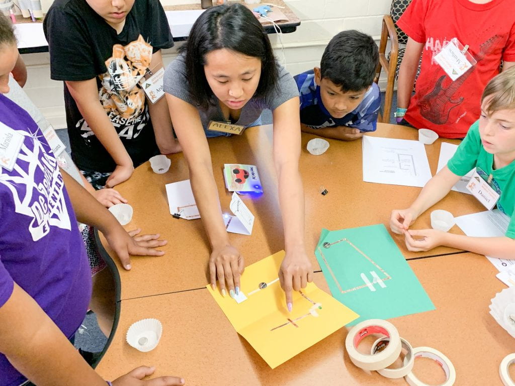 college student helps children learn basic circuitry.